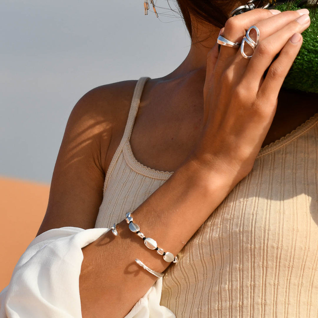 Bracelet artisanal souple N°44 en coton ciré avec perles rondes et ovales en argent massif porté par Mélody