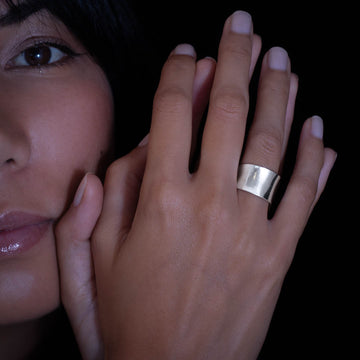 Bague artisanale pour femme en argent massif, légèrement incurvée et non patinée. Avec sa finition lisse, cette pièce sobre et élégante est un incontournable de la collection Itsara qui s’adapte à tous les styles.Bgaue porté par un modele féminin .