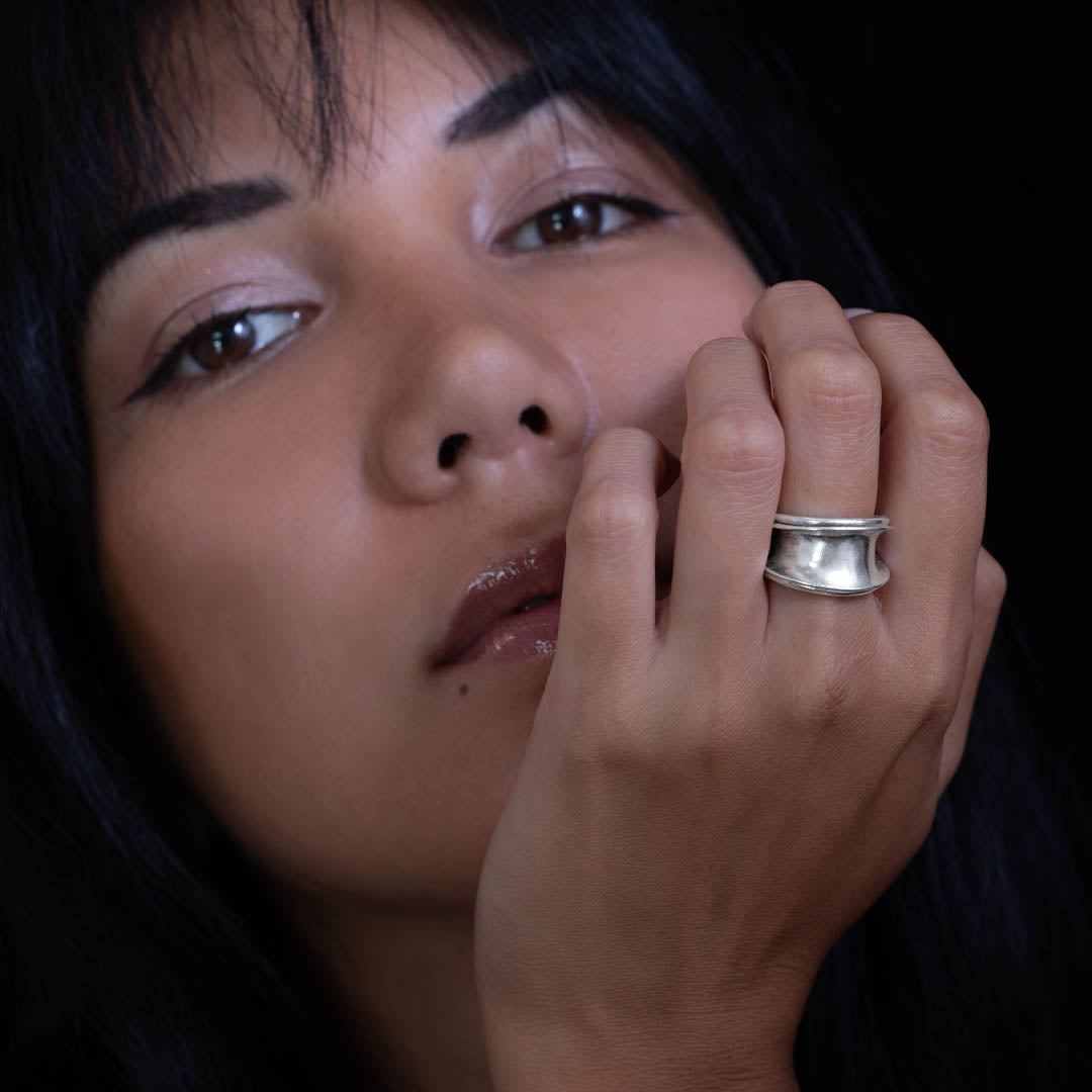 Femme portant une bague artisanale en argent massif ethnique N°22 patinée, au design enroulé avec une forme en creux sur le dessus - Itsara bijoux