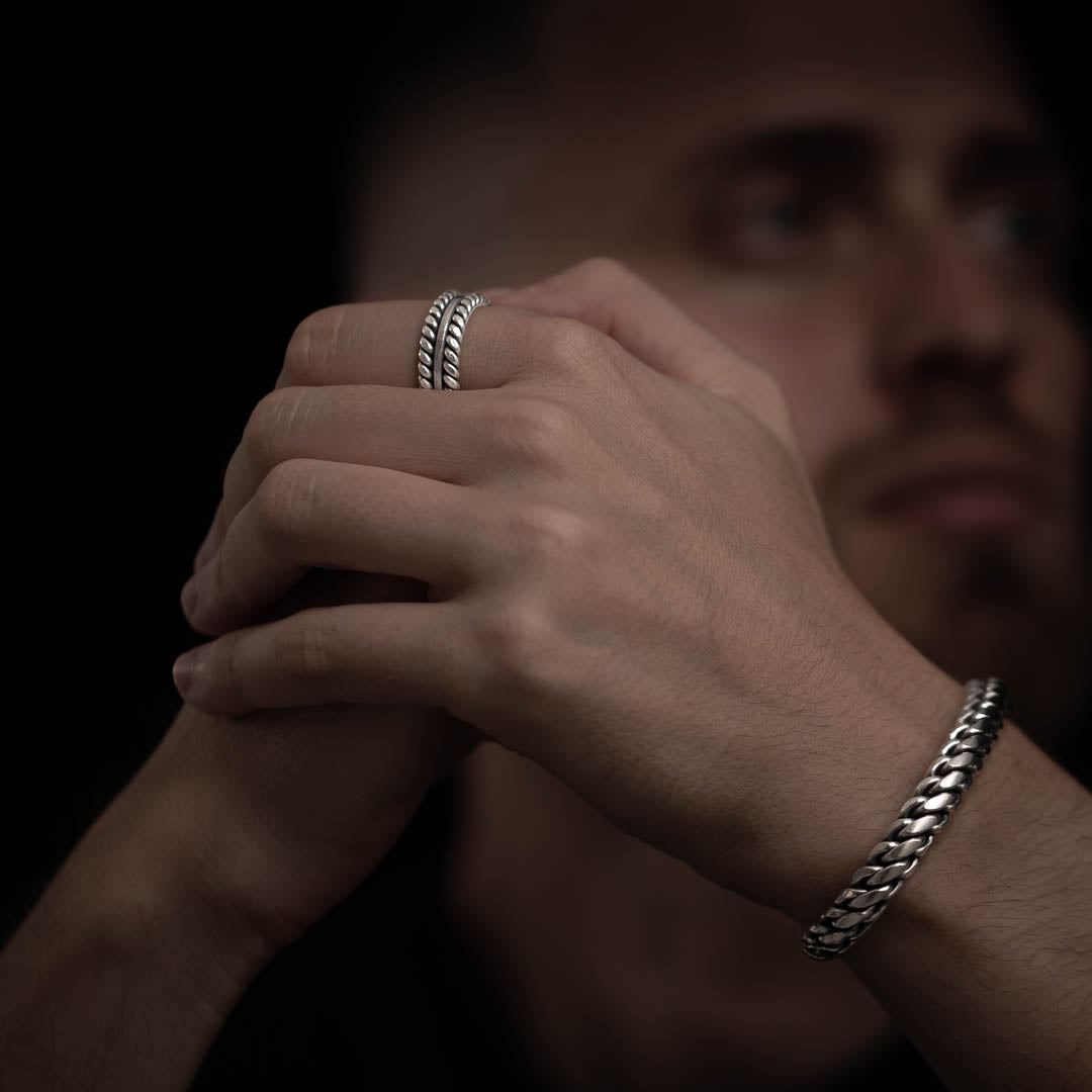  bague portée par un homme, créant un look harmonieux avec des bijoux en argent massif faits à la main.