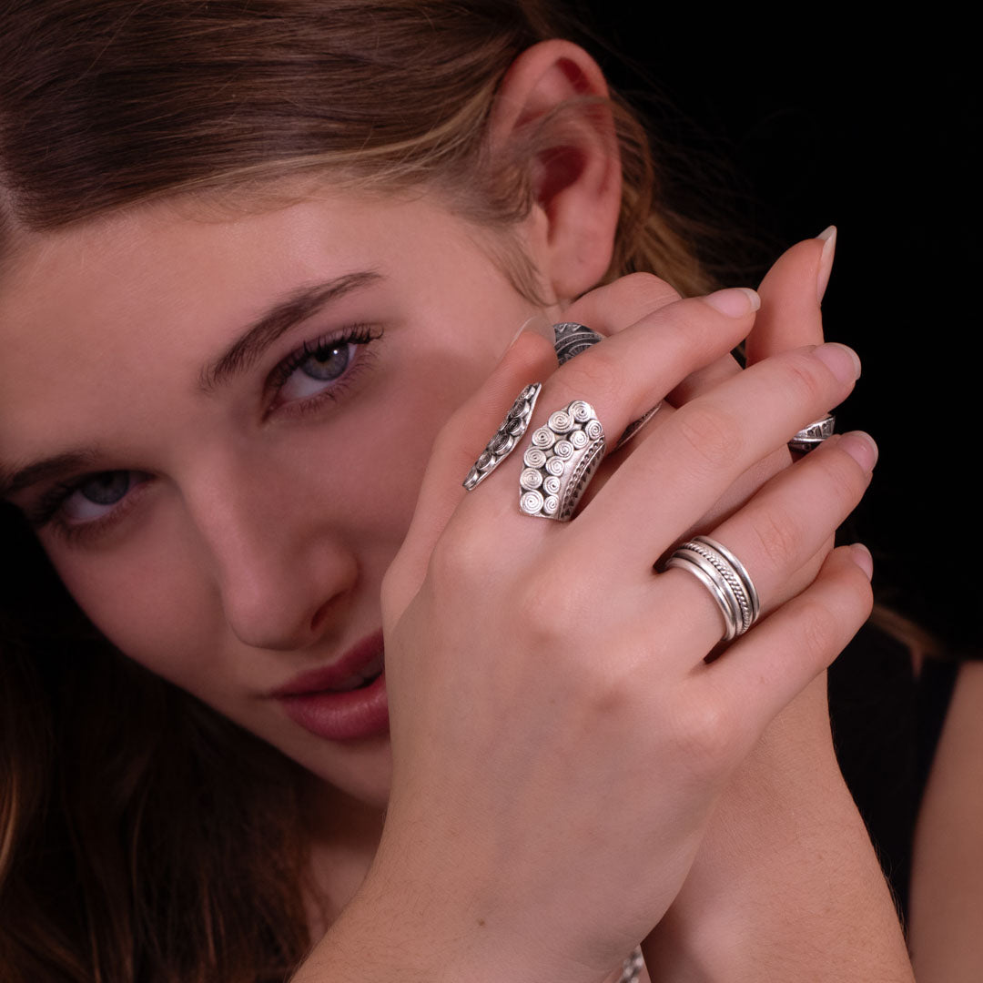 Bague artisanale en argent massif ethnique N°84 portée par une femme, travaillée en repoussé et finement patinée pour révéler des motifs tribaux. Ce bijou est inspiré des traditions ethniques ancestrales - Itsara bijoux