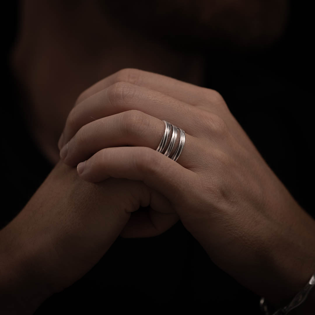 Homme portant une bague en argent N°22 composée de trois anneaux ajourés sur le dessus, griffés et patinés - Itsara bijoux