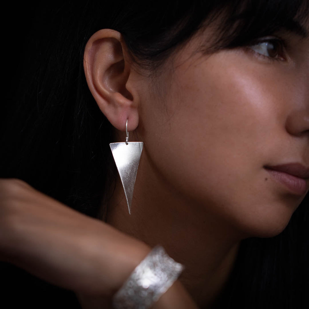 boucles d'oreilles artisanales en argent massif contemporaines N° 36 portées par Valériane, triangle à l'envers