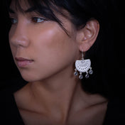 Femme portant des boucles d'oreilles N°58 de chez itsara bijoux  en argent massif avec un disque en argent massif poinçonné à main levée - Itsara Bijoux