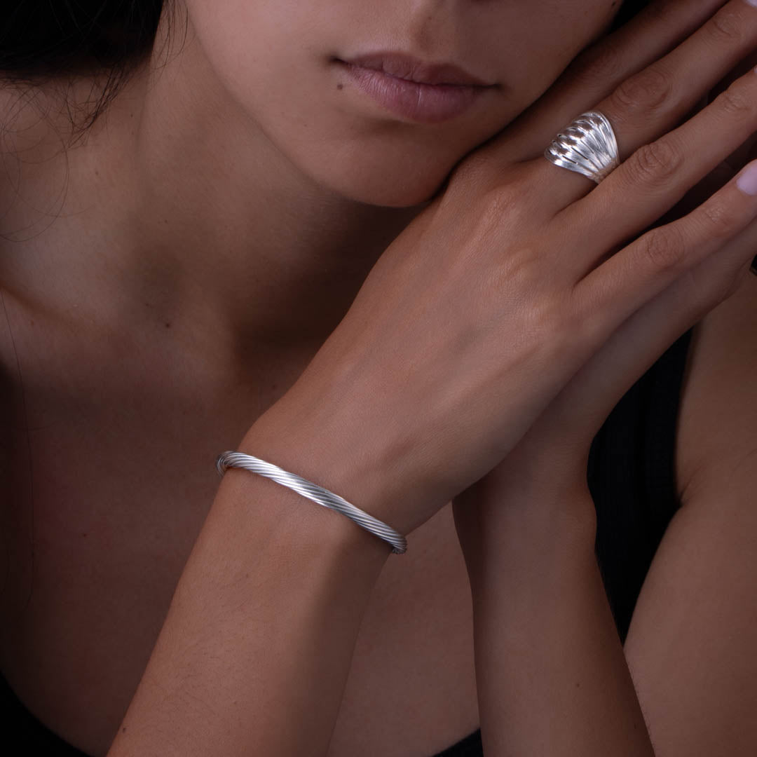 Ce bracelet N°11bis fin pour femme, réalisé à la main en argent massif, présente un magnifique tressage de fils d'argent pur. Les extrémités rassemblées et soudées ajoutent à sa finesse et à son charme - Itsara Bijoux