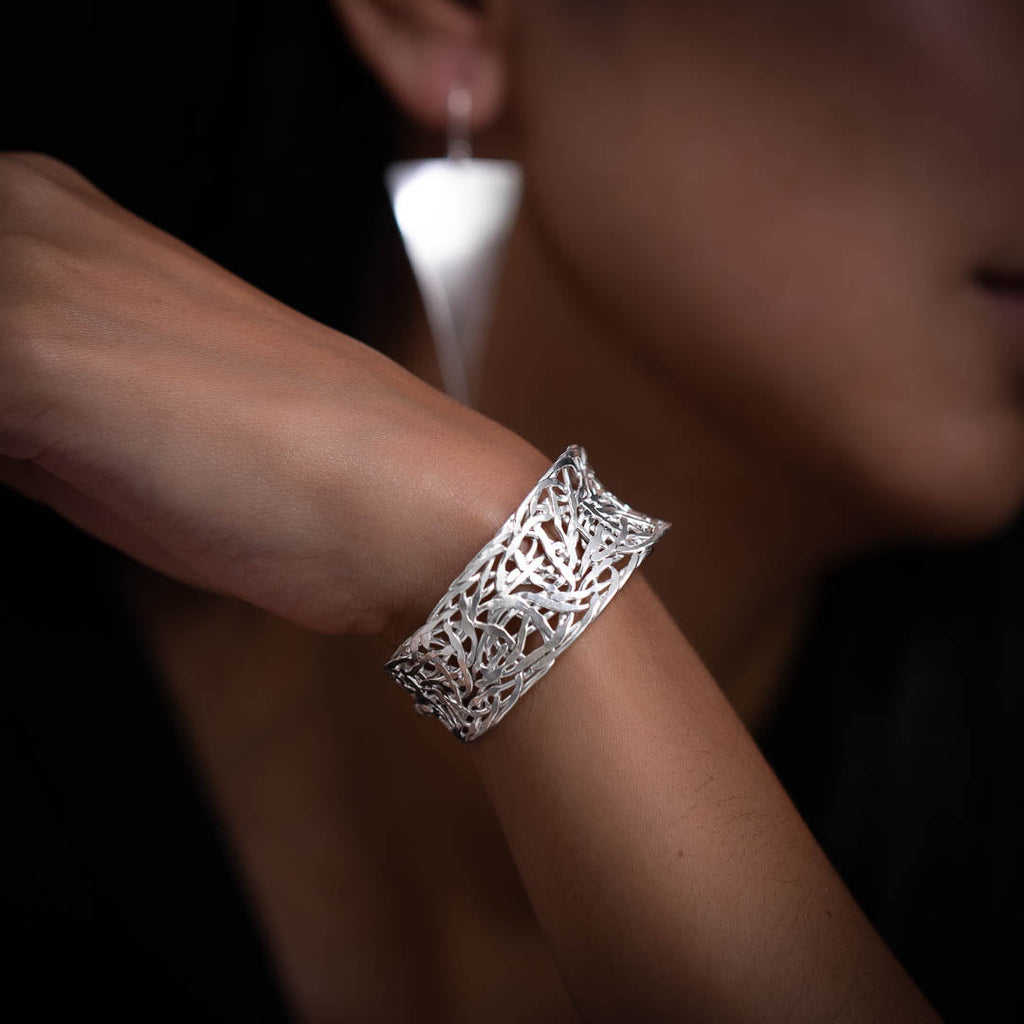 bracelet artisanal en argent massif porté par un modèle féminin. ce bracelet est entièrement fabrique par des artisans