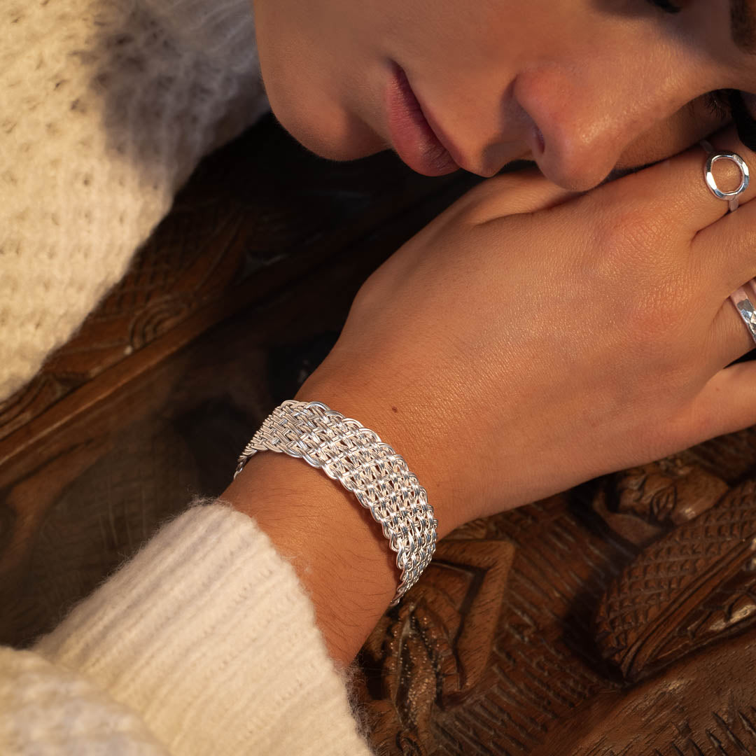 Femme portant un pull en laine blanc avec un bracelet N°29 en argent massif fait entièrement à la main par les artisans karen - Itsara Bijoux