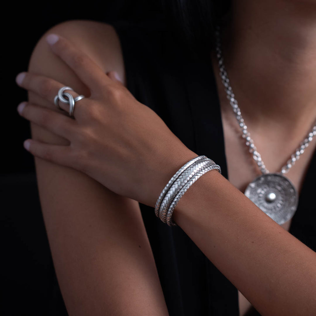 Ce bracelet N°55 pour femme est une pièce unique, tressée à la main avec des lamelles d'argent pur. La patine artisanale accentue la beauté du graphisme et assure souplesse, solidité et confort - Itsara Bijoux