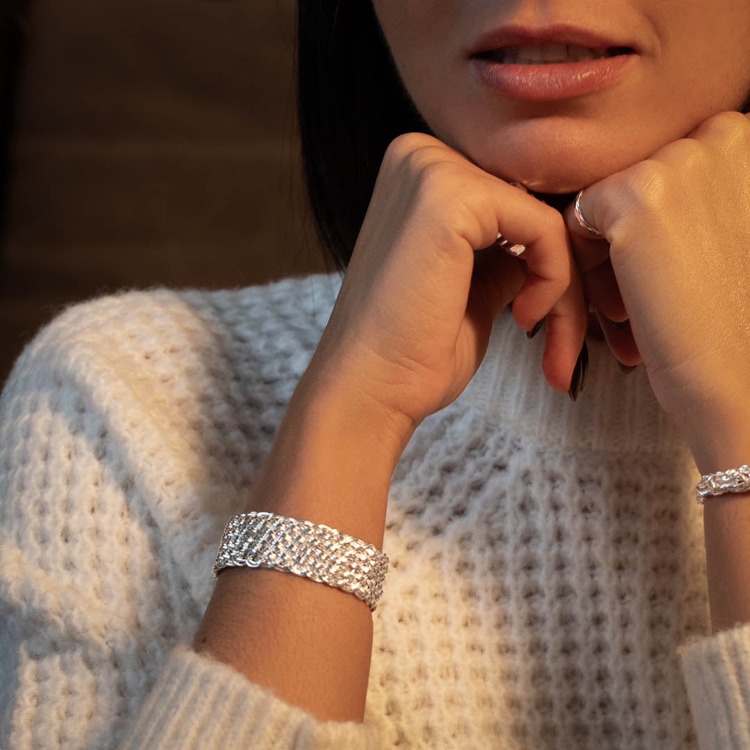 Modèle féminin N°29 portant un pull en laine blanc avec un bracelet en argent massif fait entièrement à la main - Itsara Bijoux