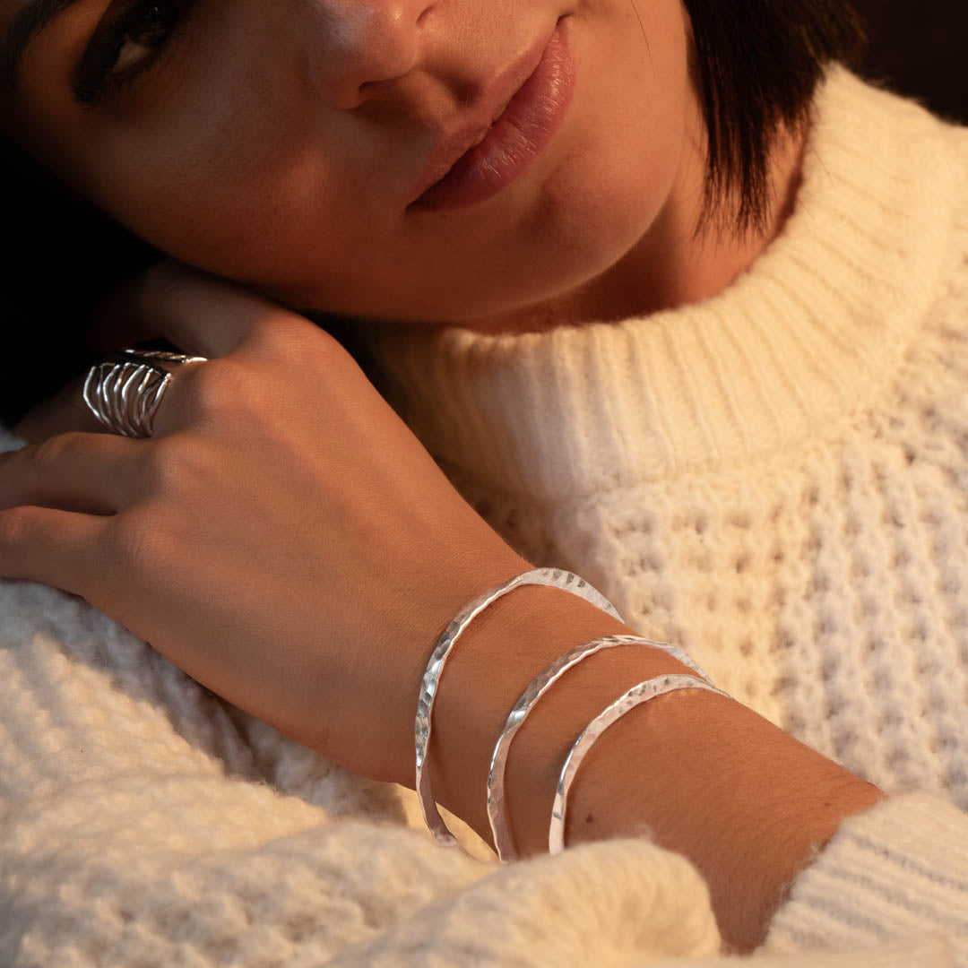 Femme portant un tricot en laine blanc un bracelet N°36 en argent massif fait à la main par des artisans - Itsara Bijoux