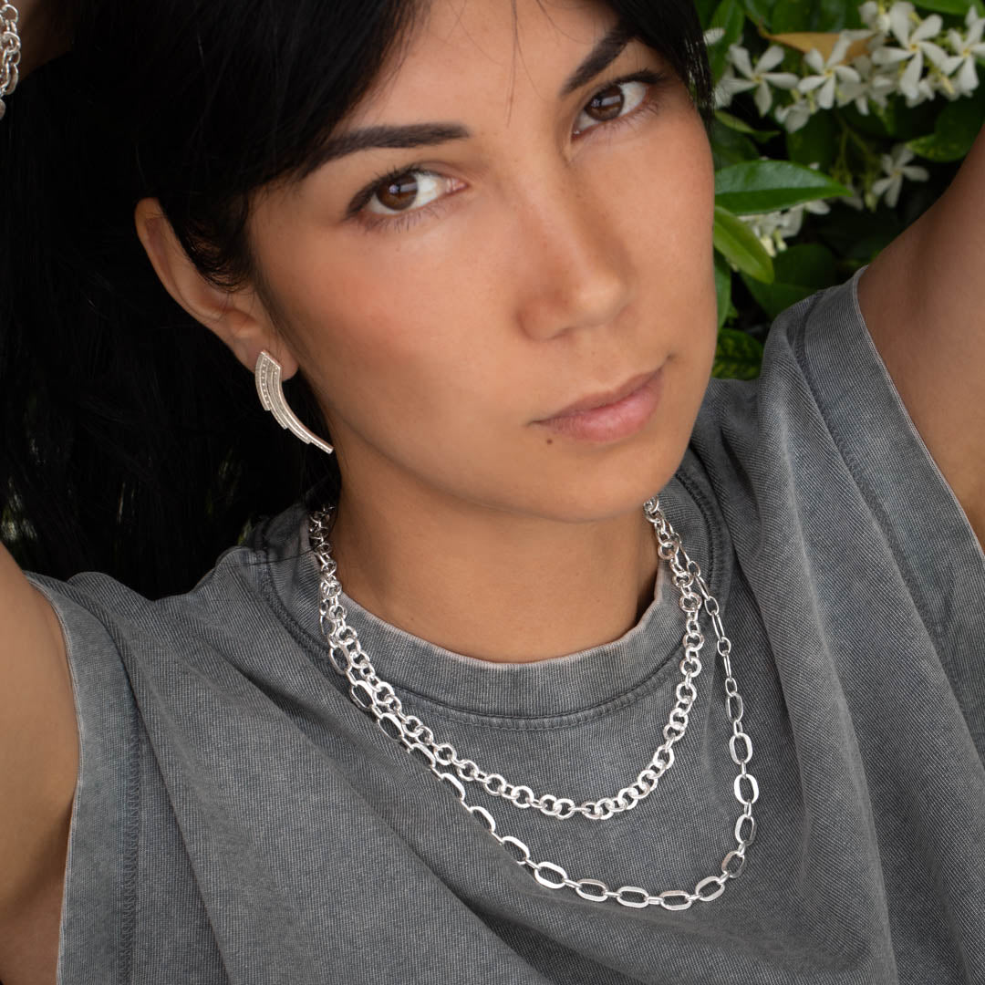 collier en chaine N21 en argent porté par une femme avec un t-shirt gris et des boucles d'oreilles. ce collier est entièrement réalisé à la main par des artisans Itsara bijoux  