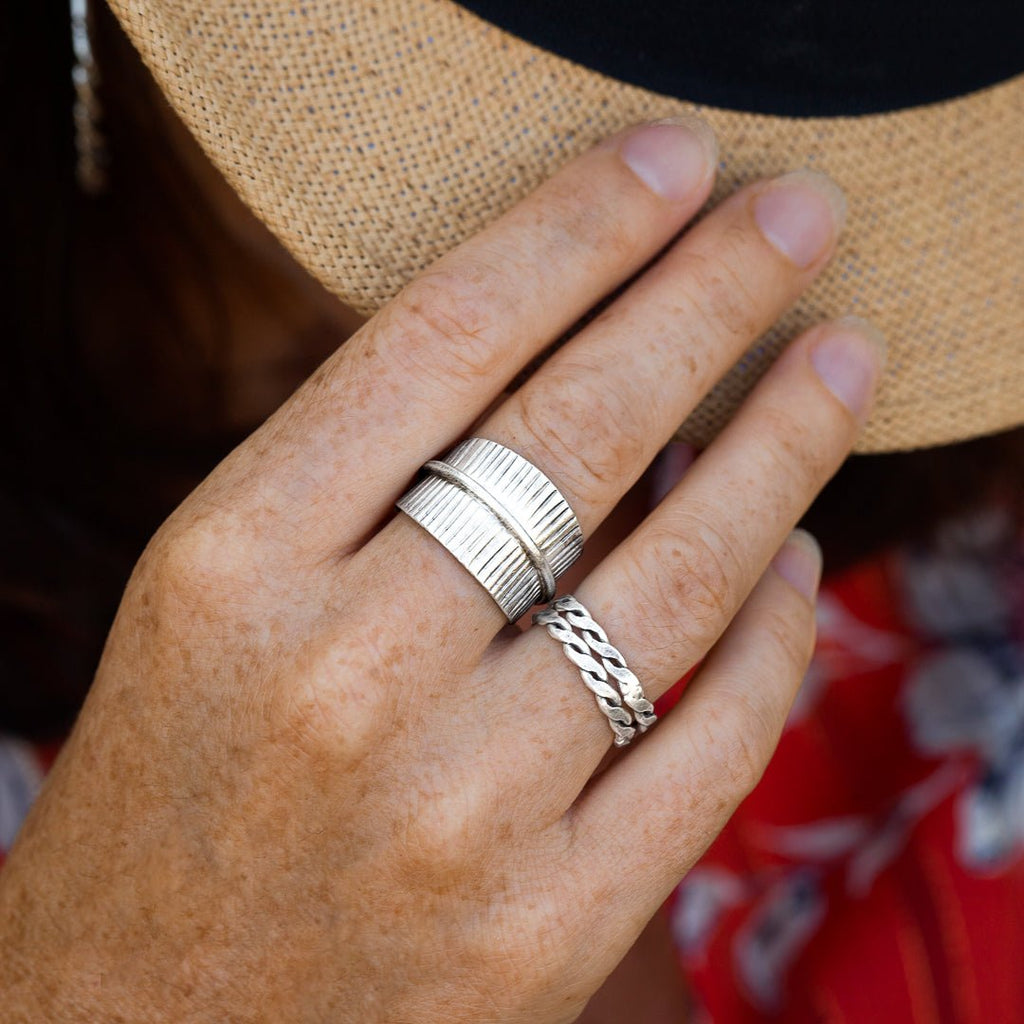 Bague en argent massif, une pièce dynamique entièrement faite à la main. Son design avec nervures verticales et un ourlet central en relief évoque la texture du bambou, sublimée par une patine délicate.