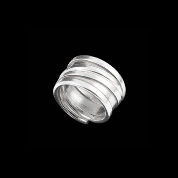 Bague artisanale en argent massif enroulée sur elle-même, bijou fait à la main avec un design modulable et légèrement patiné