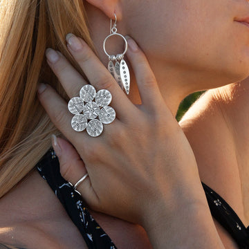 Femme portant une bague ethnique en argent massif, poinçonnée à main levée, représentant la 'Fleur de la Vie' avec une symbolique spirituelle forte