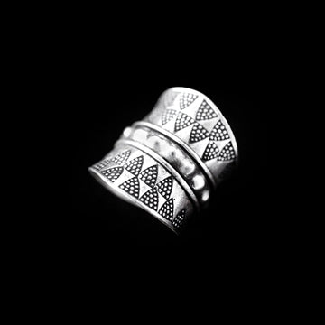 Bague en argent massif de style ethnique, ornée de motifs géométriques et ceinturée de ronds en repoussé, bijou artisanal inspiré des tribus du triangle d'or.