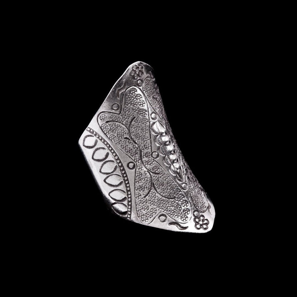 Grande bague artisanale en argent massif ethnique N°82, poinçonnée à la main avec des motifs tribaux et floraux. Ce bijou ethnique cintré épouse parfaitement la forme du doigt, avec un style bouclier qui symbolise la force et la protection. Patinée pour révéler les détails du relief, cette bague est un véritable hommage au savoir-faire traditionnel - Itsara bijoux