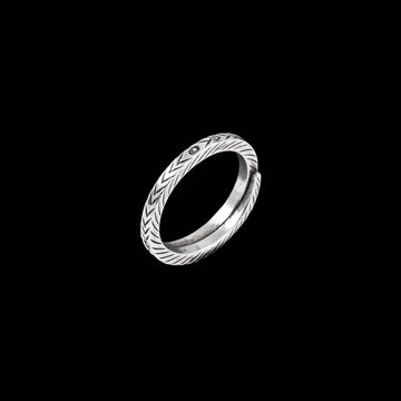 bague artisanale en argent massif, travaillée à la main. Son anneau est orné de nervures délicates en relief, évoquant des motifs naturels et subtilement patinés. Un bijou intemporel, parfait pour une touche discrète et raffinée.