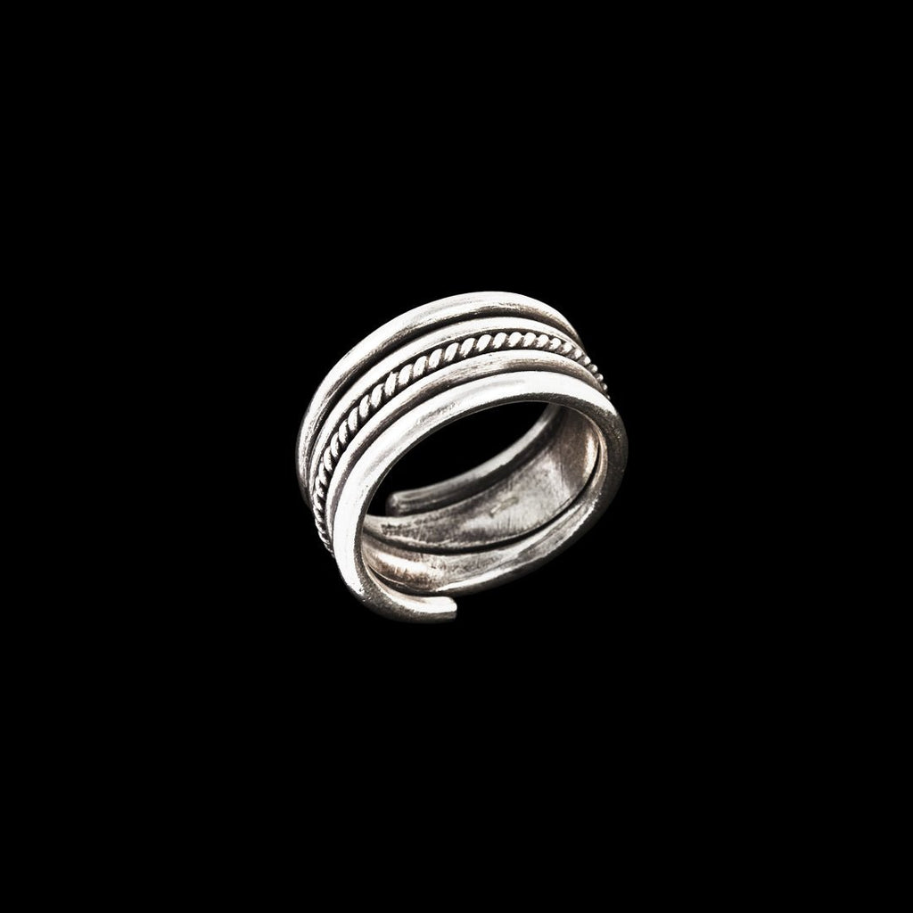 Bague artisanale de caractère pour homme, en argent massif. Son design épais, orné d'un fil d'argent torsadé et patiné au centre, apporte une touche ethnique et puissante à ce modèle intemporel.