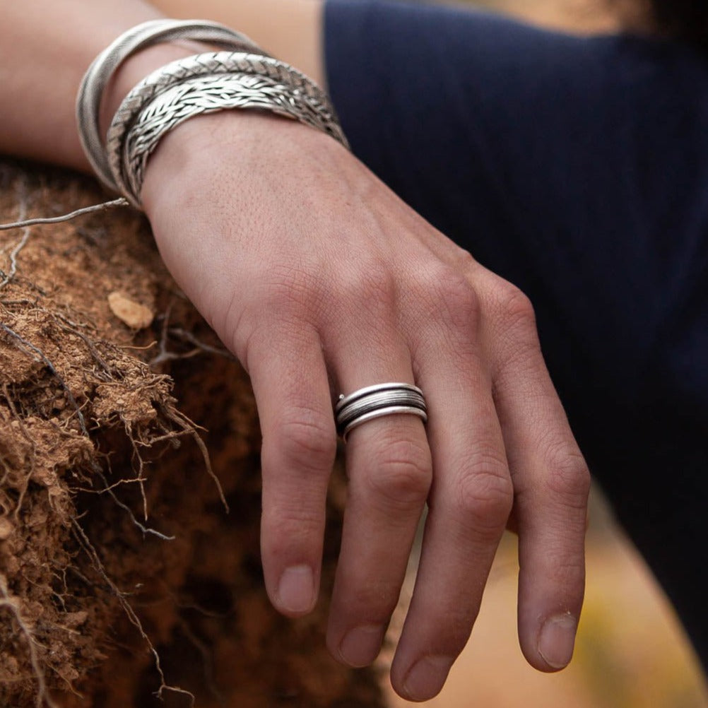 Bague artisanale pour homme en argent massif, ornée d'une surface bombée au centre, patinée pour faire ressortir ses reliefs