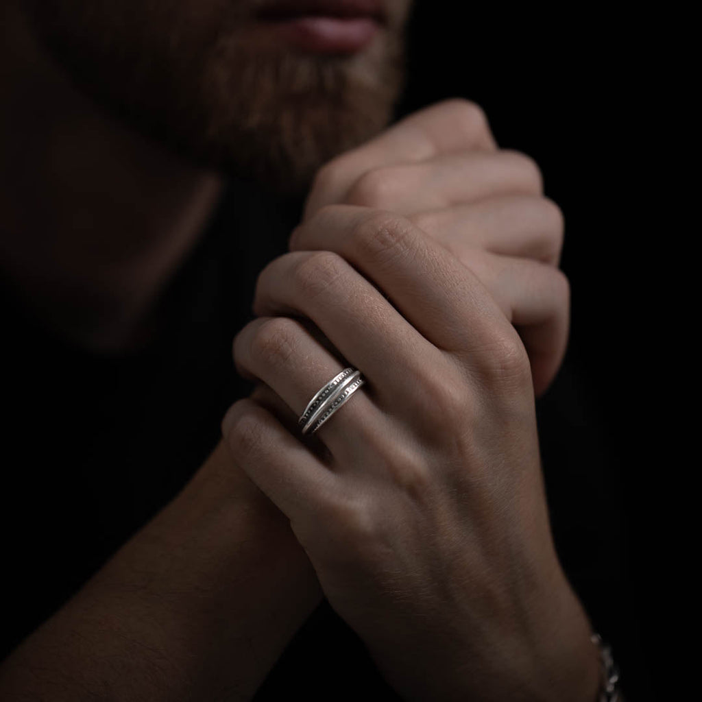 Bague artisanale en argent massif, élégante et sobre. Un anneau discret et intemporel, avec des motifs gravés et patinés sur les côtés pour un effet raffiné.