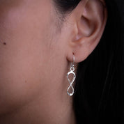 Boucles d'oreilles en argent massif contemporaine N°17 pour femme, pendantes et artisanales, illustrant le symbole de l'infini. Leur légèreté et leur éclat leur confèrent un charme contemporain - Itsara bijoux