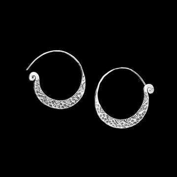 Boucles d'oreilles artisanales ethniques en argent massif, poinçonnées et martelées pour un look unique. Leur finition patinée et leur design original en font de jolies créoles pleines de caractère.