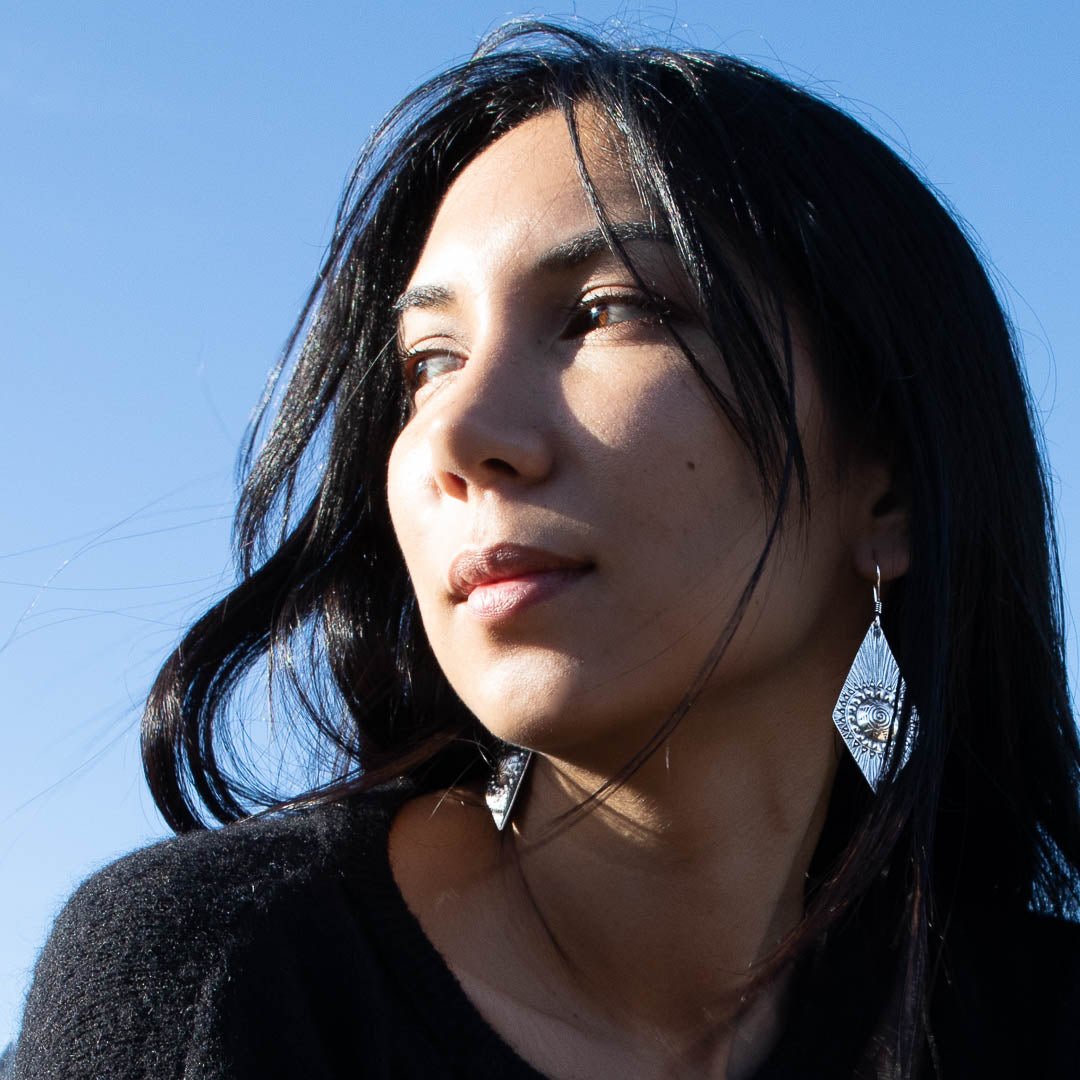 Boucles d'oreilles en argent Ethniques N°27 fabriquées entièrement à la main par les artisans karen, en argent massif avec des motifs géométriques, portée par un modèle féminin - Itsara bijoux