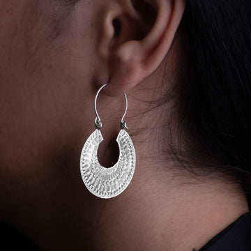 modèle féminin portant les Boucles d'oreilles en argent massif au motif rayonnant