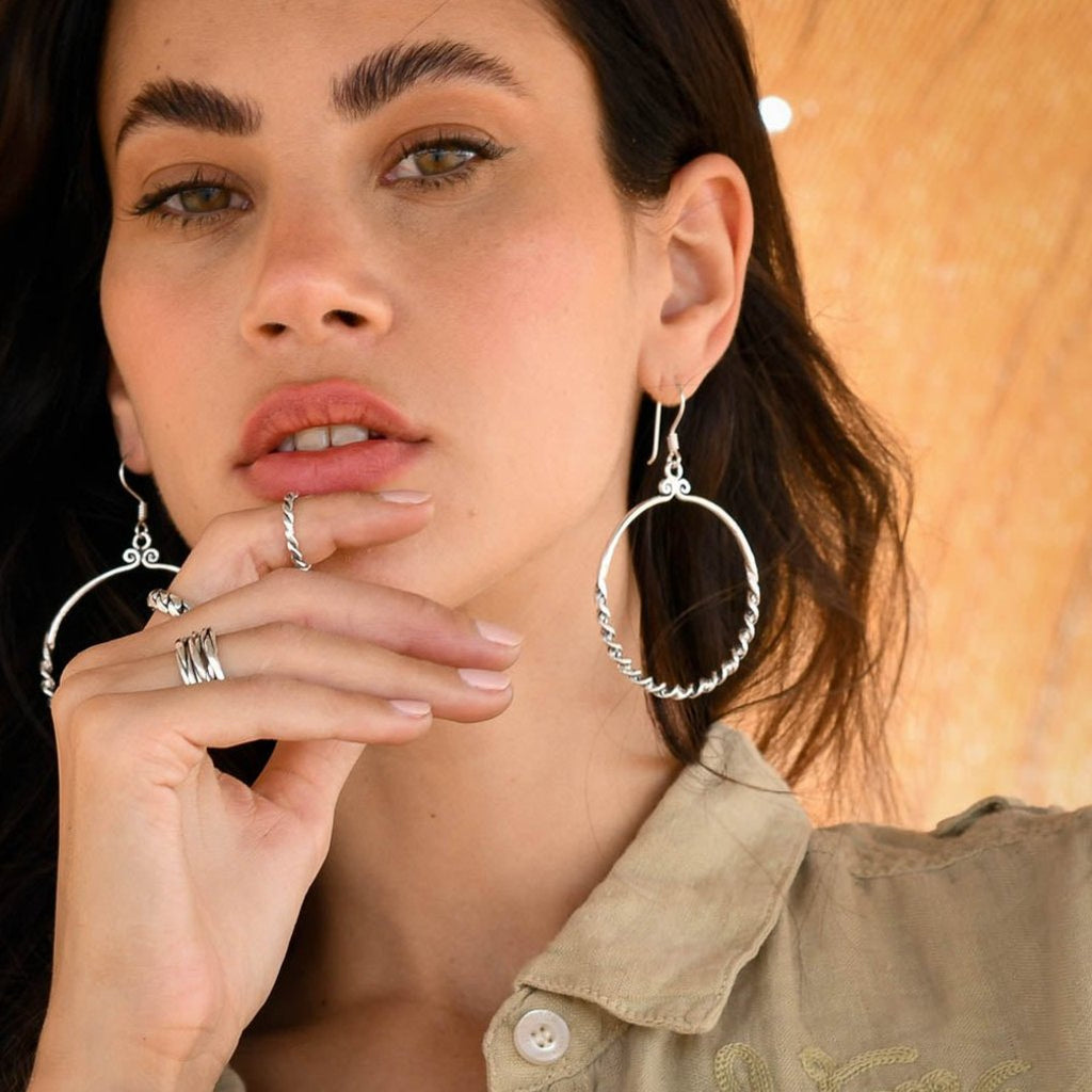 Boucles d'oreilles en argent Ethniques N°91 en forme de créoles torsadées, réalisées à la main en argent massif, portées par une femme - Itsara Bijoux