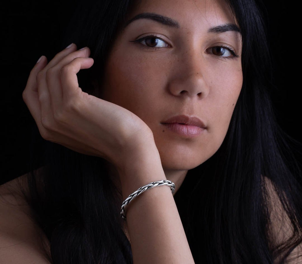 femme portant un bracelet en argent massif réalisé en tressage de fils épais d'argent pur et patiné pour mettre en valeur le travail artisanal