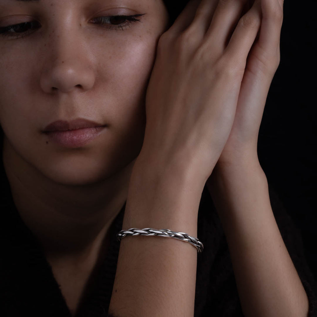 Modèle féminin portant un bracelet N°12 en argent massif réalisé en tressage de fils épais d'argent pur et patiné fait entièrement à la main - Itsara Bijoux